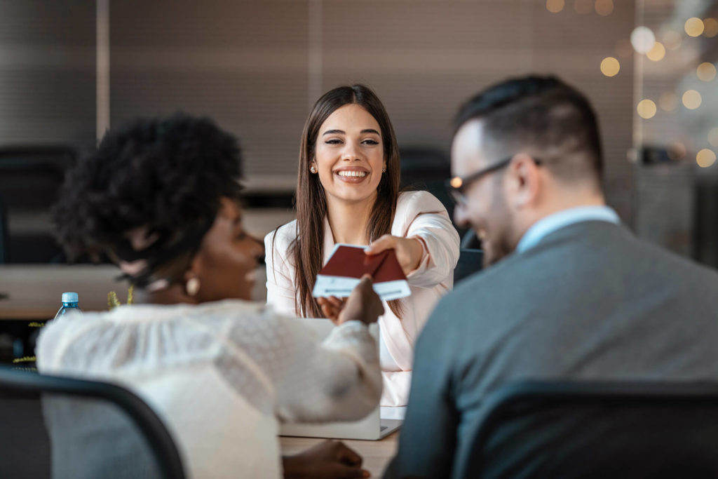 Smiling travel agent helping clients build customer rapport by giving the best airline consolidator deals through Sky Bird Travel & Tours.