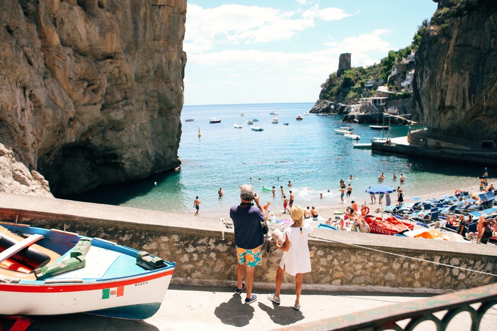 A beautiful image of a married couple traveling on a romantic journey to the Amalfi Coast in Italy. This image is featured in the Sky Bird Travel & Tours blog, "Best Destinations for Honeymooners," which shows travel agents the most romantic locations for honeymoon!