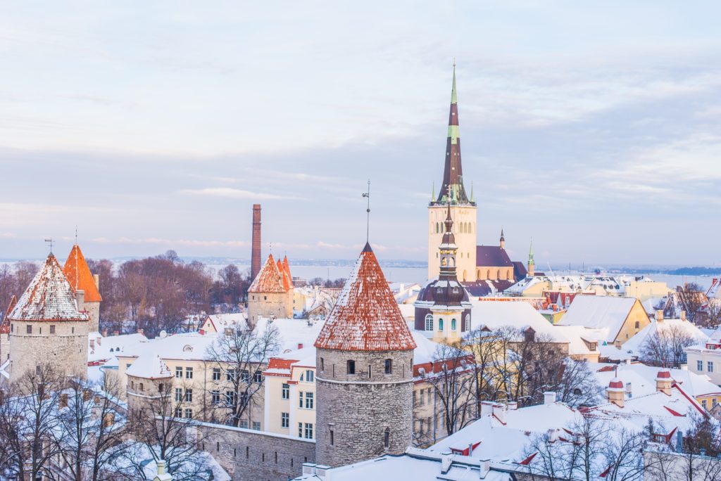 The cityscape of Old Town in the historic district of Tallinn, which is covered in snow and perfect for travel agents booking vacations. This image is featured in the Sky Bird Travel & Tours blog post, "Top 10 Destination: The Baltics," which describes the best things to do while on vacation in the Baltic States.