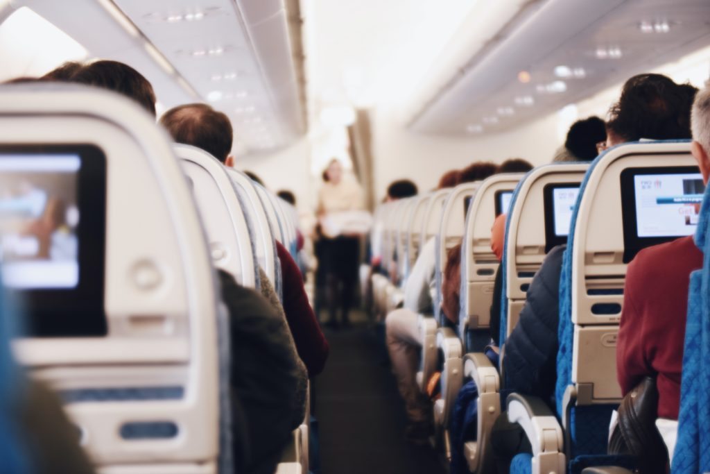 Featured in "Why Travel Agents Need GDS" by Sky Bird Travel, this image shows the interior of an airplane cabin on flight