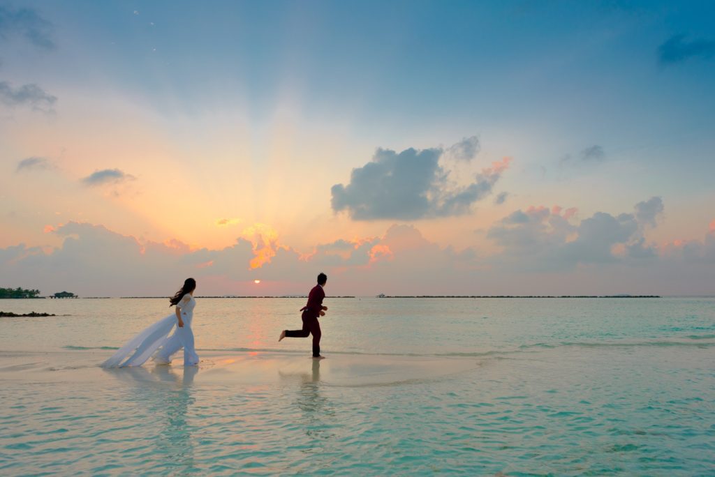 Featured in Discovering Niche Markets by Sky Bird Travel & Tours, this image shows a bride and groom on a destination wedding at the beach.