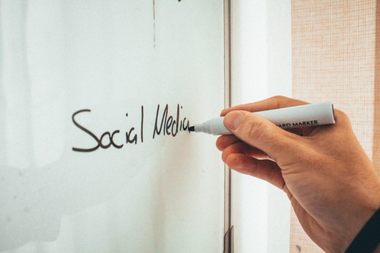 Featured in Social media Marketing for Travel Agents by Sky Bird Travel & Tours, this image shows the world social media written on a white board.
