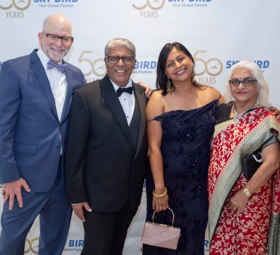 Guest Posing with Mr. and Mrs. Shah at Sky Bird Travel’s Golden Jubilee 50th Anniversary 2026