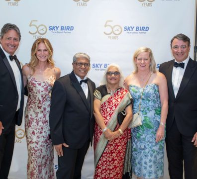 Guest Taking a Photo with Mr. and Mrs. Shah at Sky Bird Travel’s 50th Anniversary